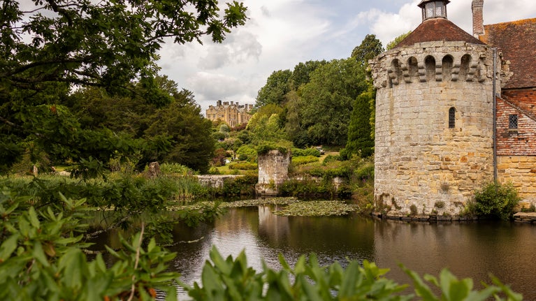 View across the moat of the Old Castle ruins towards the Victorian house at Scotney Castle, Kent